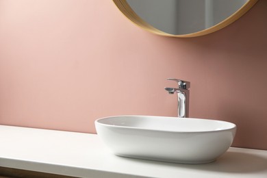 Photo of Bathroom vanity with sink and mirror, space for text