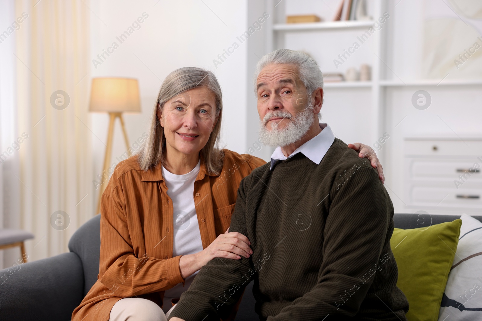 Photo of Portrait of happy elderly couple on sofa at home