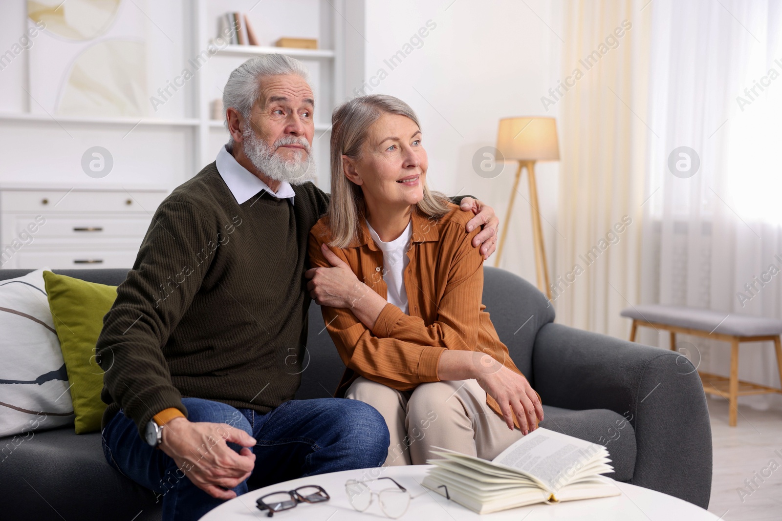 Photo of Happy elderly couple on sofa at home