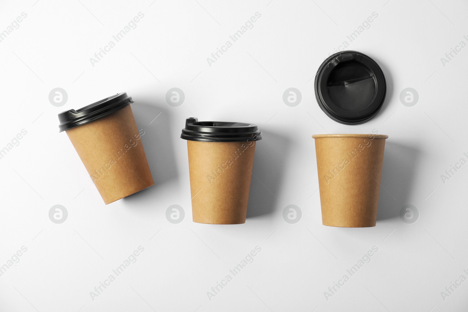 Paper cups with lids on white background, flat lay. Mockup for design Photo of Paper cups with lids on white background, flat lay. Mockup for design