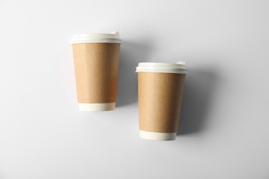 Photo of Paper cups with lids on white background, flat lay. Mockup for design