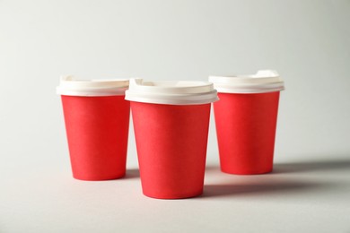 Photo of Paper cups with lids on grey background. Mockup for design
