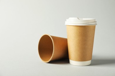 Photo of Paper cups with lids on grey background. Mockup for design