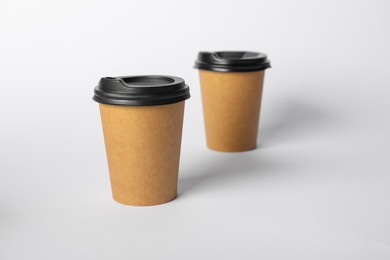 Photo of Paper cups with lids on white background, selective focus. Mockup for design