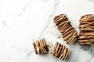 Photo of Delicious chocolate puffed rice bars on white marble table, flat lay. Space for text