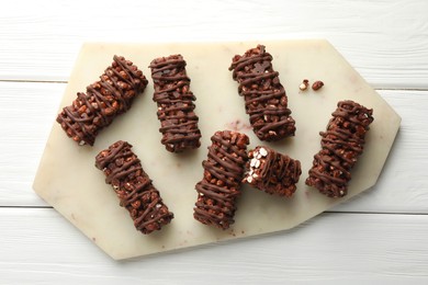 Photo of Delicious chocolate puffed rice bars on white wooden table, top view