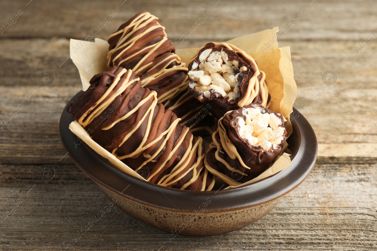 Photo of Delicious chocolate puffed rice bars on wooden table, closeup