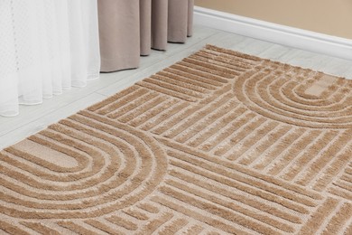 Photo of Stylish soft rug with pattern on floor indoors, closeup