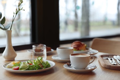 Photo of Delicious breakfast served on wooden table in cafe