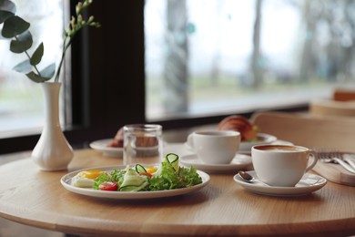 Photo of Delicious breakfast served on wooden table in cafe