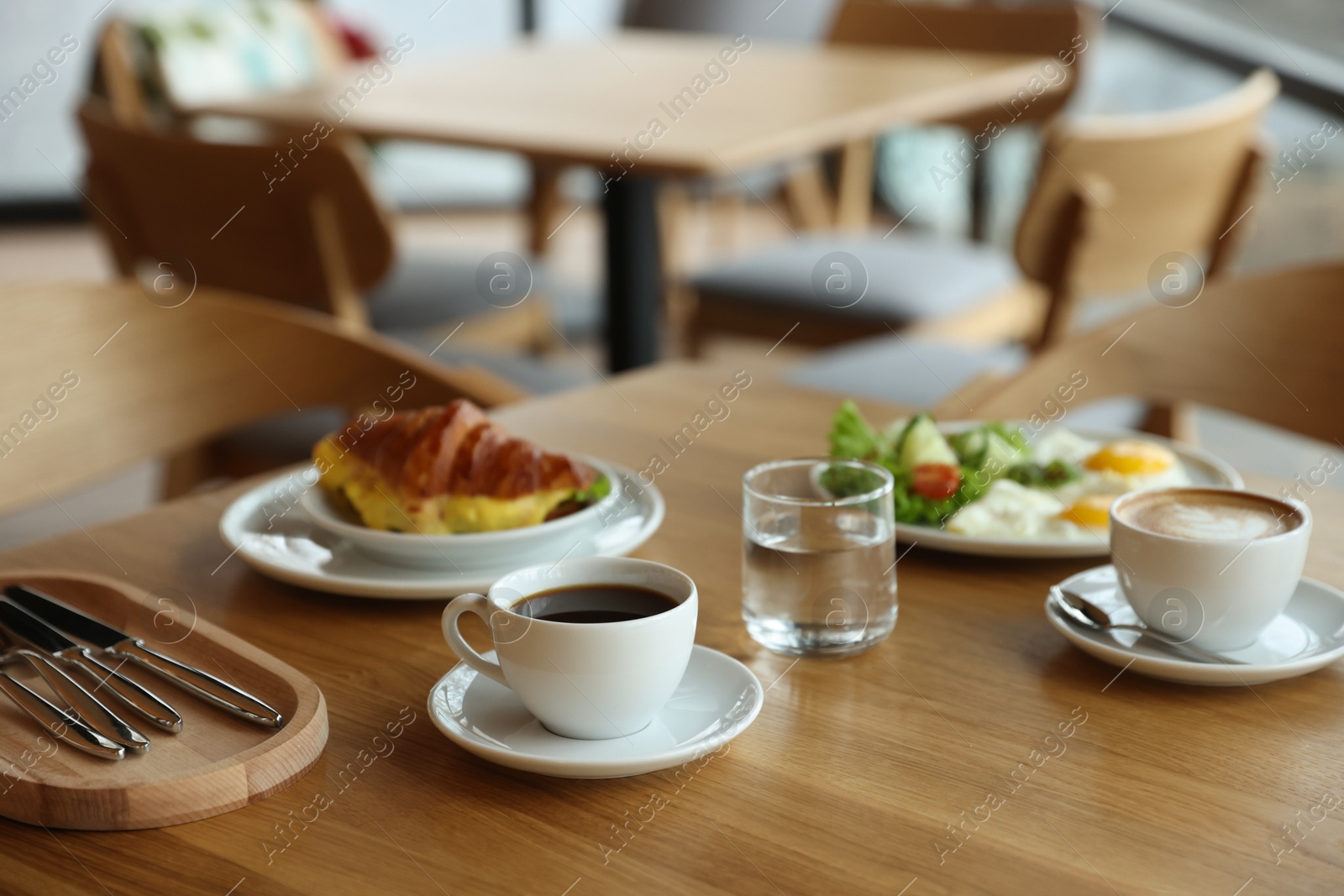 Photo of Delicious breakfast served on wooden table in cafe