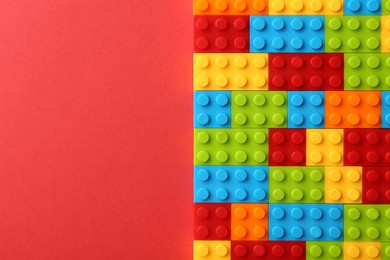 Photo of Construction toy. Colorful building bricks on red background, top view with space for text