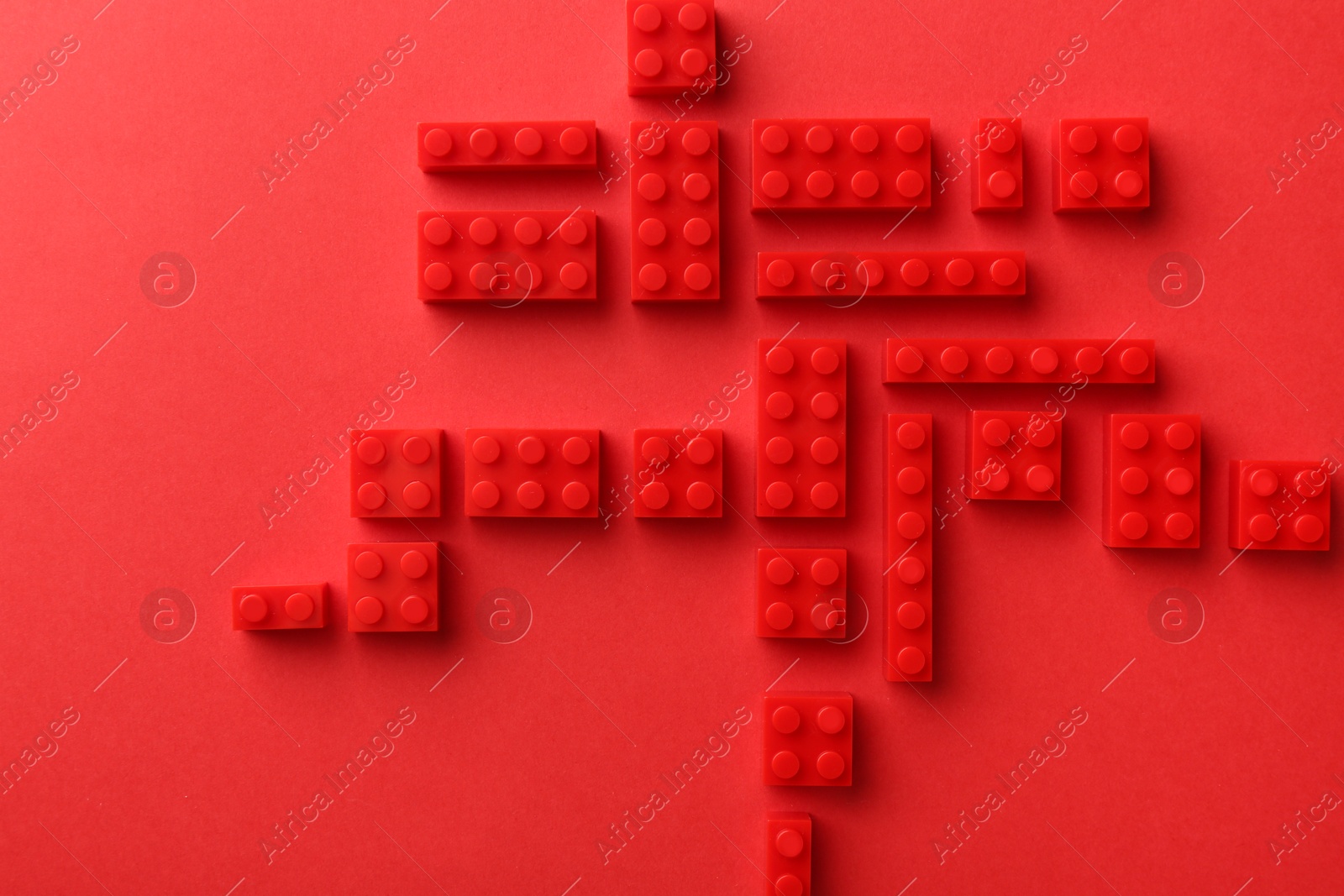 Photo of Construction toy. Building bricks on red background, flat lay