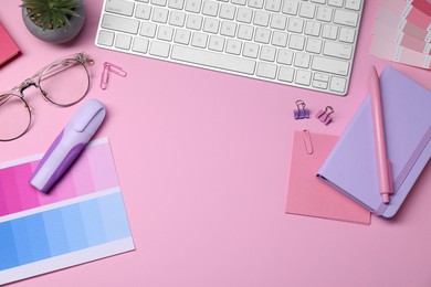 Photo of Designer's workplace with keyboard and stationery on pink background, flat lay. Space for text