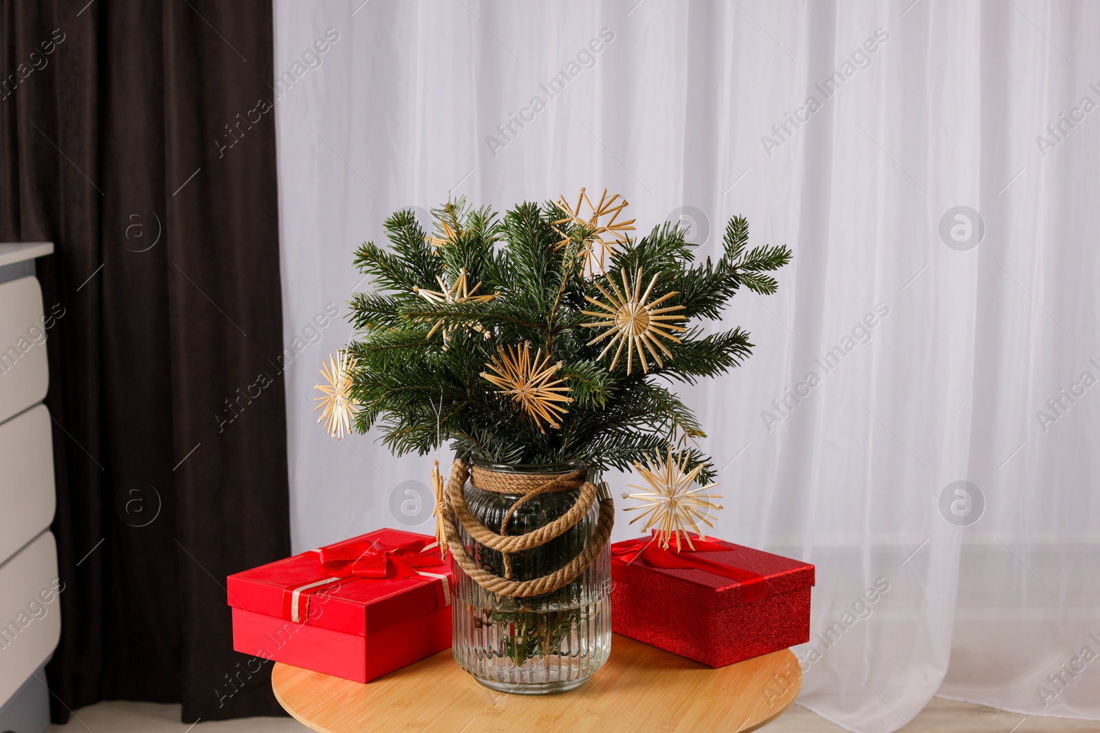 Photo of Beautiful composition of decorated fir tree branches and Christmas gifts on table indoors