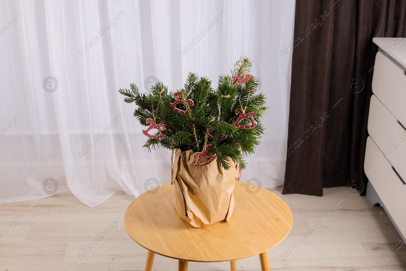 Photo of Beautiful Christmas composition of decorated fir tree branches on table indoors