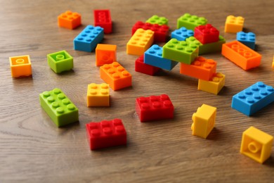 Photo of Construction toy. Colorful building bricks on wooden table, closeup