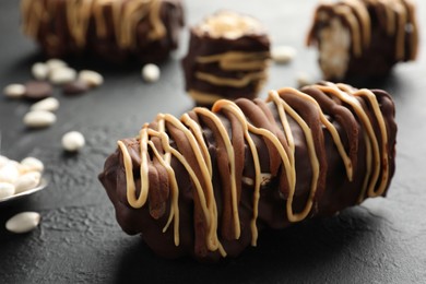 Photo of Delicious chocolate puffed rice bars on dark gray textured table, closeup