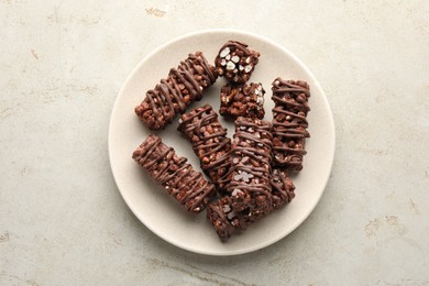 Photo of Delicious chocolate puffed rice bars on gray textured table, top view