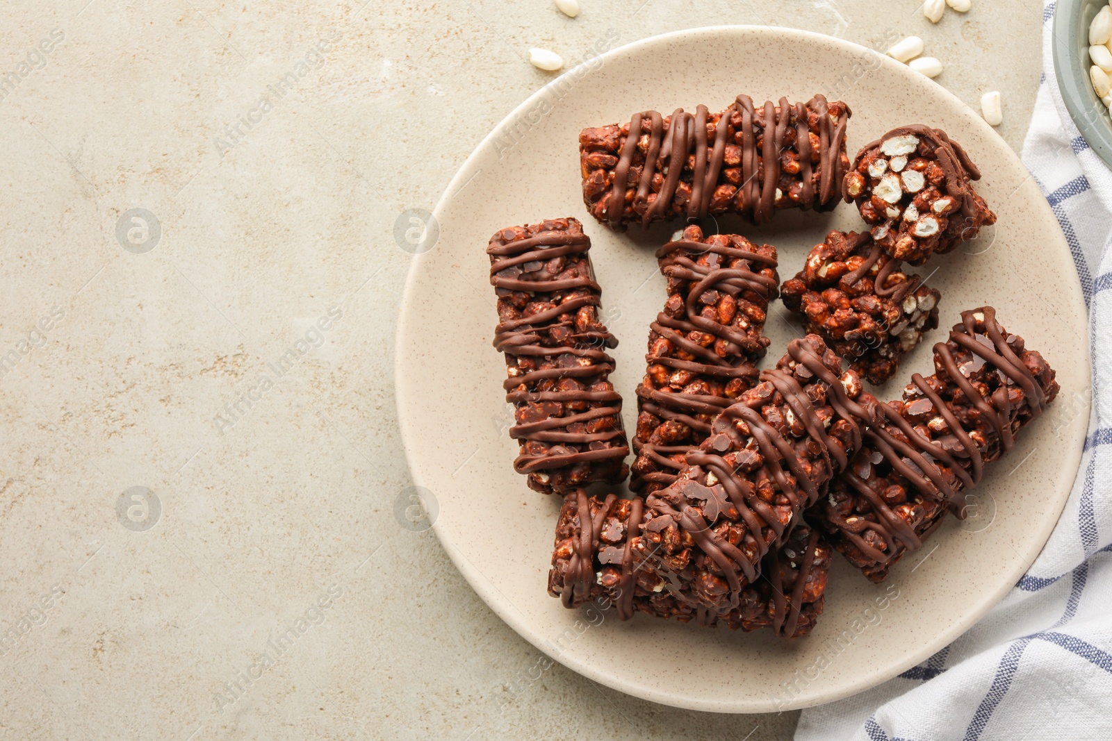 Photo of Delicious chocolate puffed rice bars on gray textured table, top view. Space for text