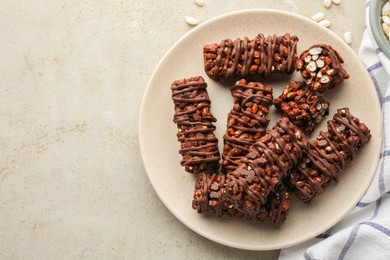 Photo of Delicious chocolate puffed rice bars on gray textured table, top view. Space for text