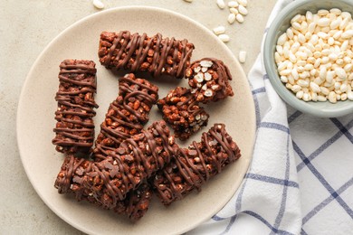 Photo of Delicious chocolate puffed rice bars on gray textured table, flat lay