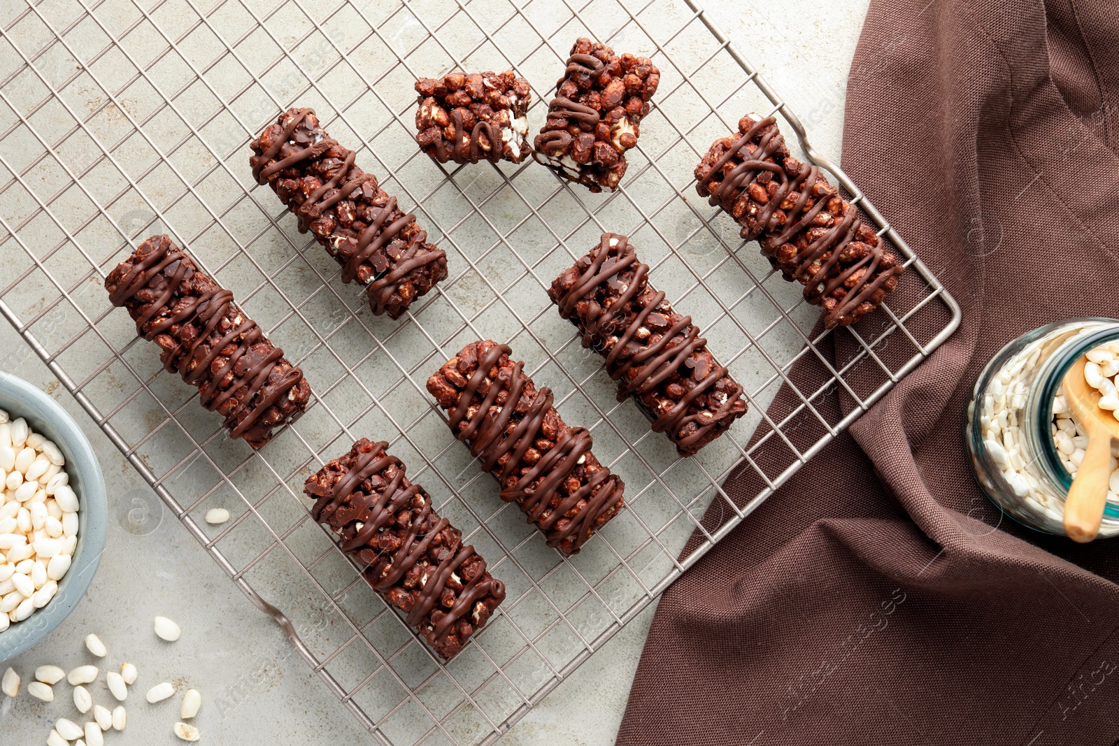 Photo of Delicious chocolate puffed rice bars on gray textured table, flat lay