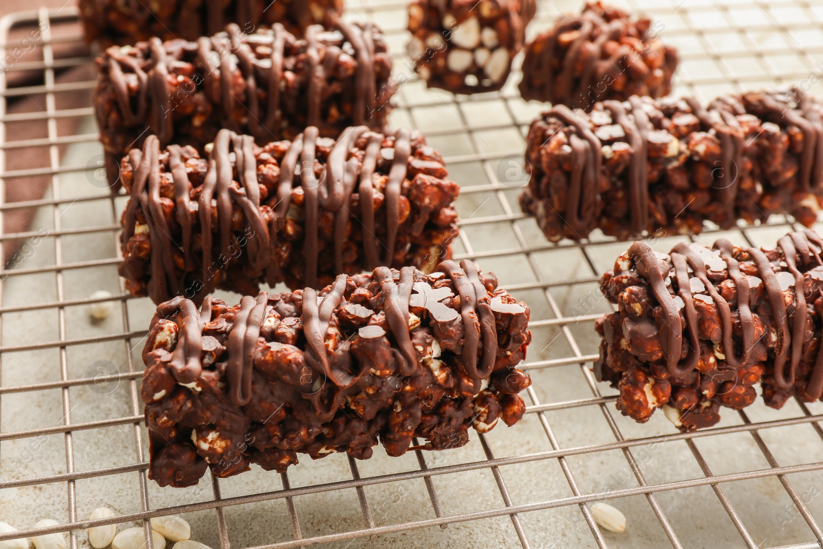 Photo of Delicious chocolate puffed rice bars on gray textured table, closeup