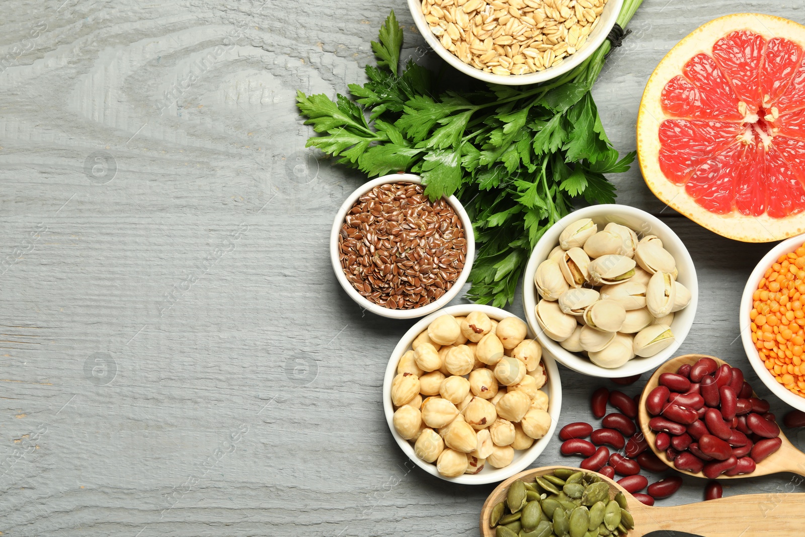 Photo of Superfood. Different healthy food products on grey wooden table, flat lay. Space for text