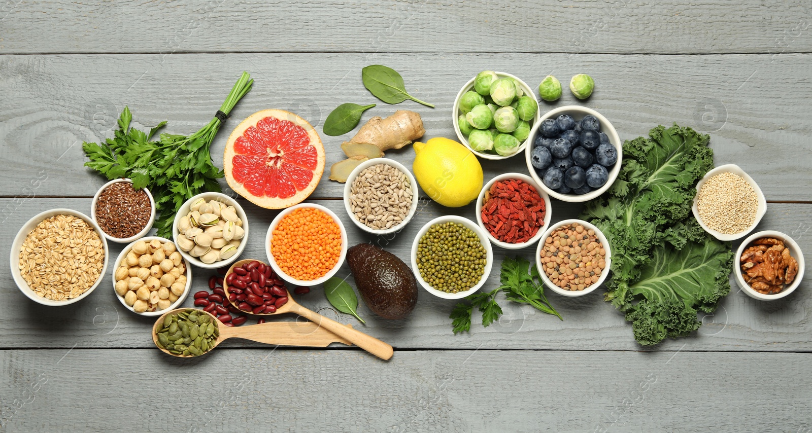 Photo of Superfood. Different healthy food products on grey wooden table, flat lay