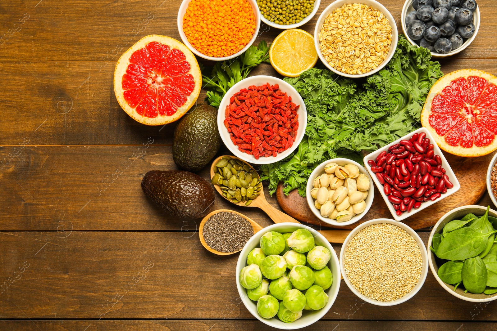 Photo of Superfood. Different healthy food products on wooden table, flat lay. Space for text