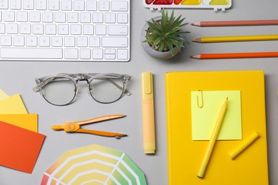 Photo of Designer's workplace. Flat lay composition with stationery and keyboard on light grey background