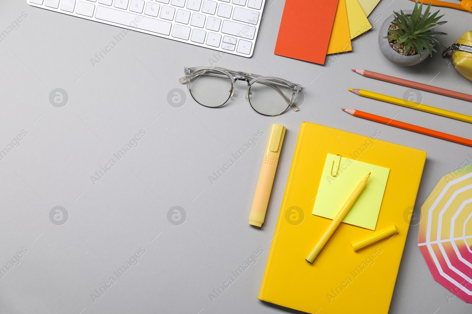 Photo of Designer's workplace. Flat lay composition with stationery and keyboard on light grey background, space for text