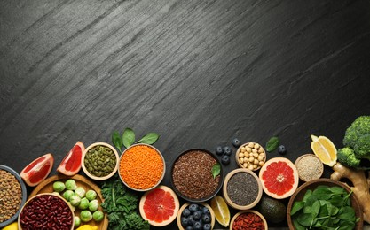 Photo of Different superfood products on black table, flat lay. Space for text