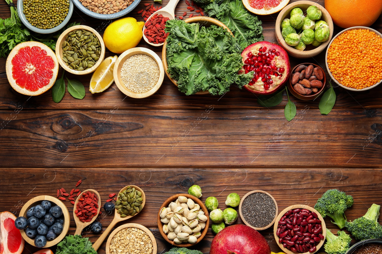 Photo of Different superfood products on wooden table, flat lay. Space for text