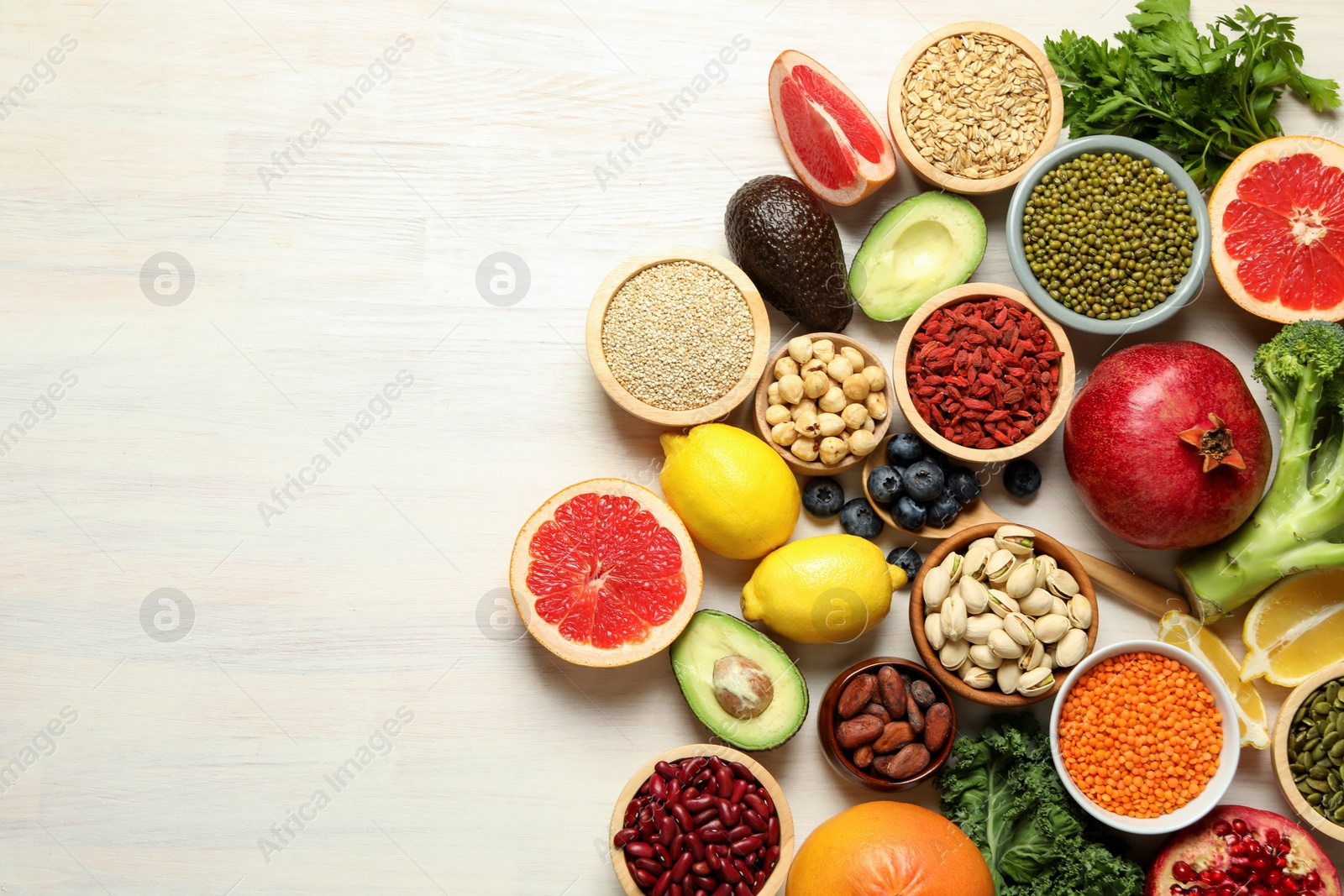 Photo of Different superfood products on white table, flat lay. Space for text