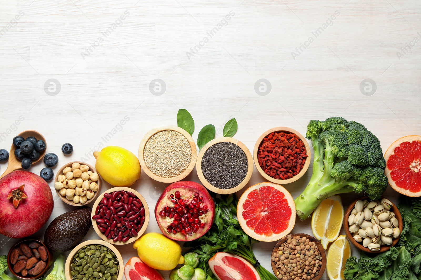 Photo of Different superfood products on white table, flat lay. Space for text