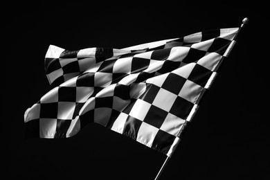 Photo of One racing checkered flag on black background