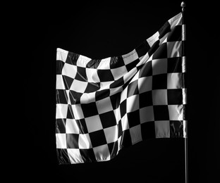 Photo of One racing checkered flag on black background, space for text