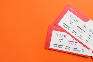 Photo of Travel agency. Flight tickets on orange background, top view. Space for text