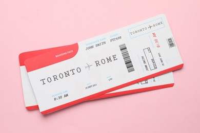 Photo of Travel agency. Flight tickets on pink background, top view