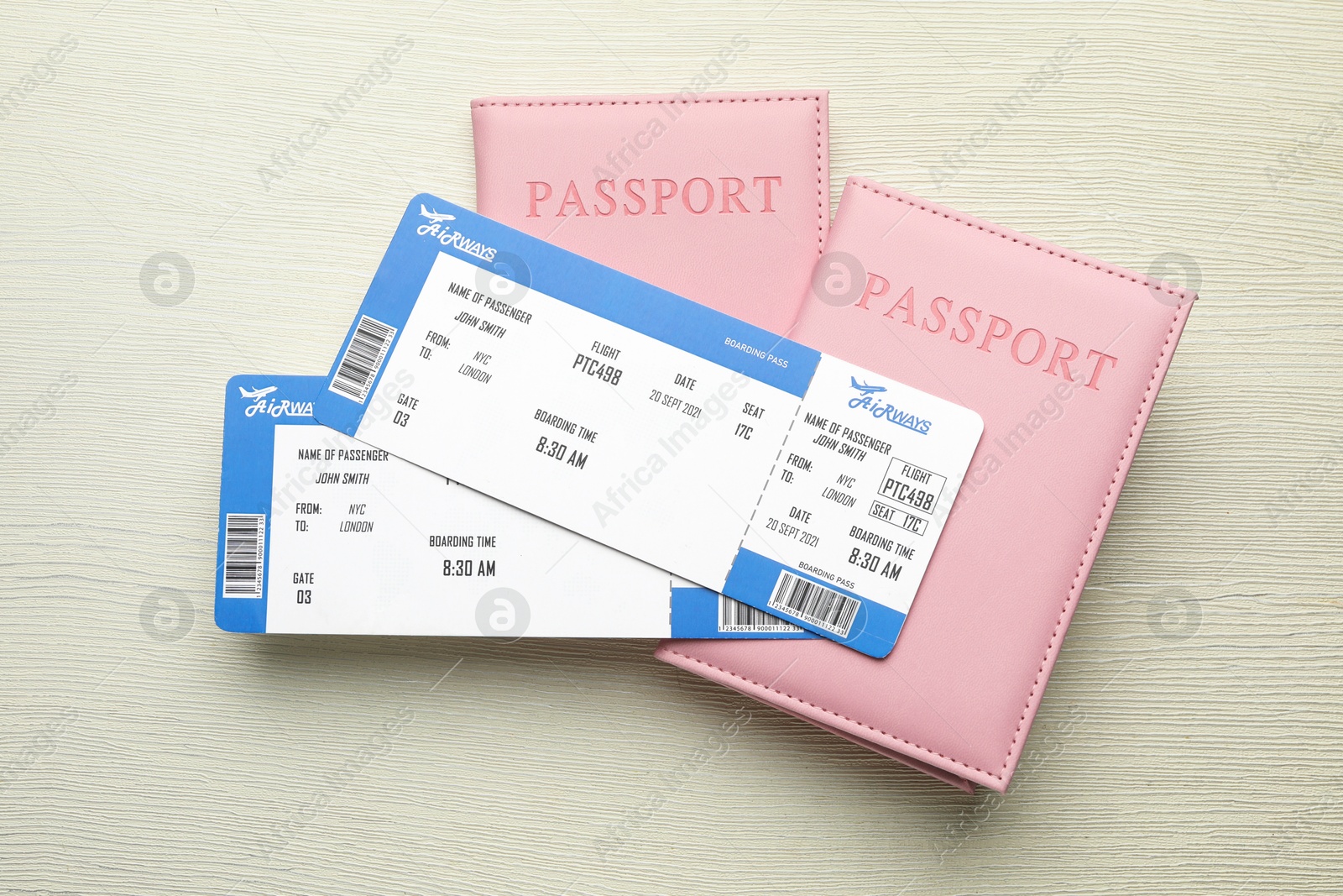 Photo of Travel agency. Flight tickets and passports on light wooden table, top view