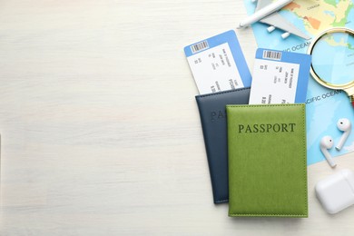 Photo of Travel agency. Flight tickets, passports, world map and plane model on light wooden table, flat lay. Space for text