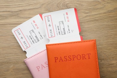 Photo of Travel agency. Flight tickets and passports on wooden table, top view