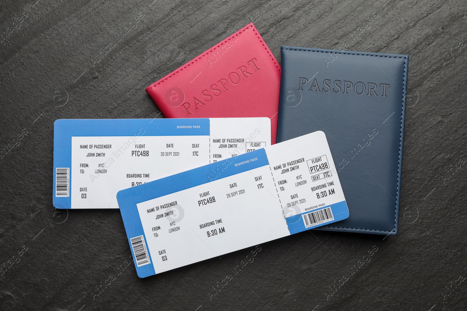 Photo of Travel agency. Flight tickets and passports on dark textured table, flat lay