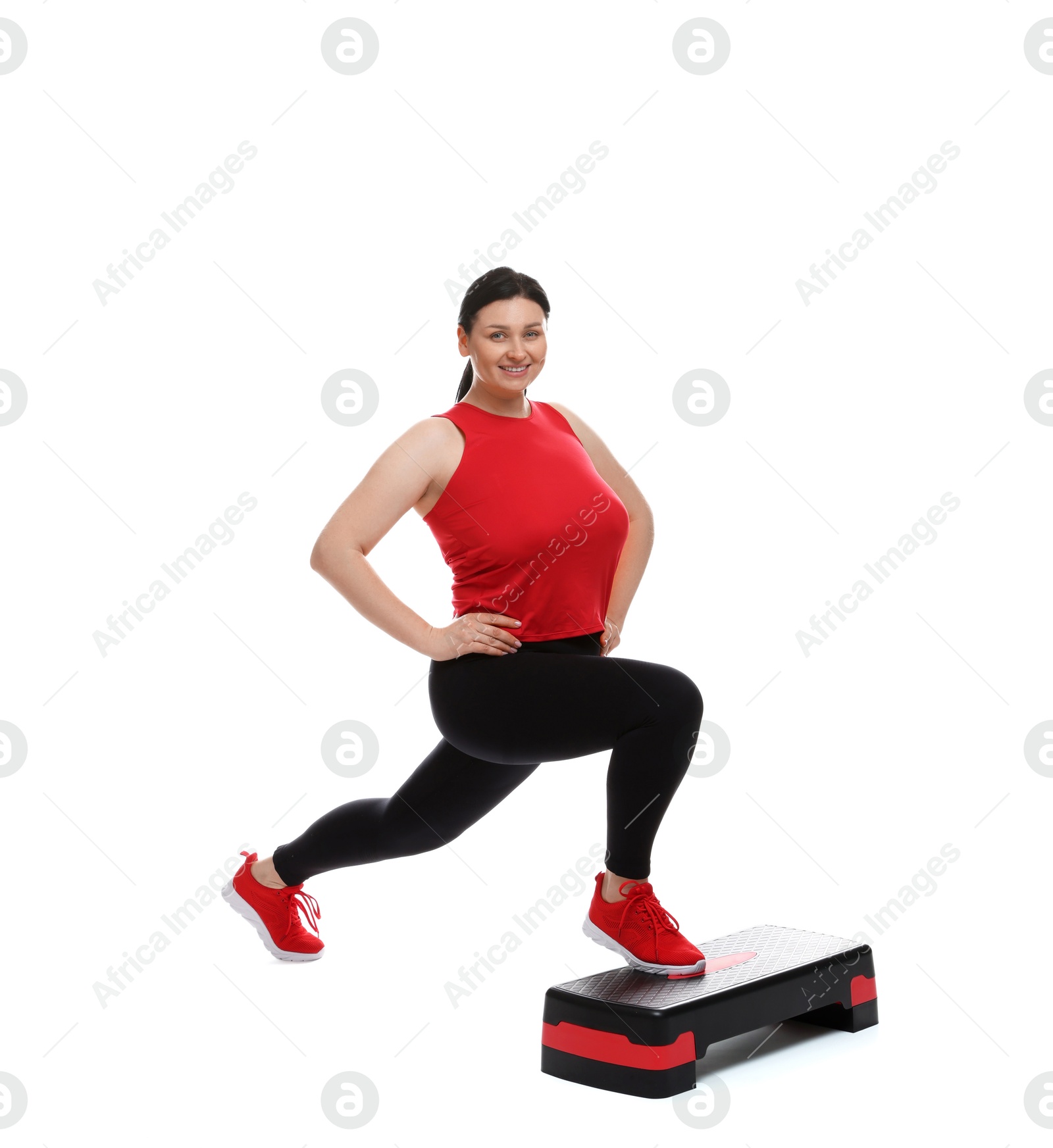 Photo of Plus size woman in gym clothes doing exercise with step platform on white background