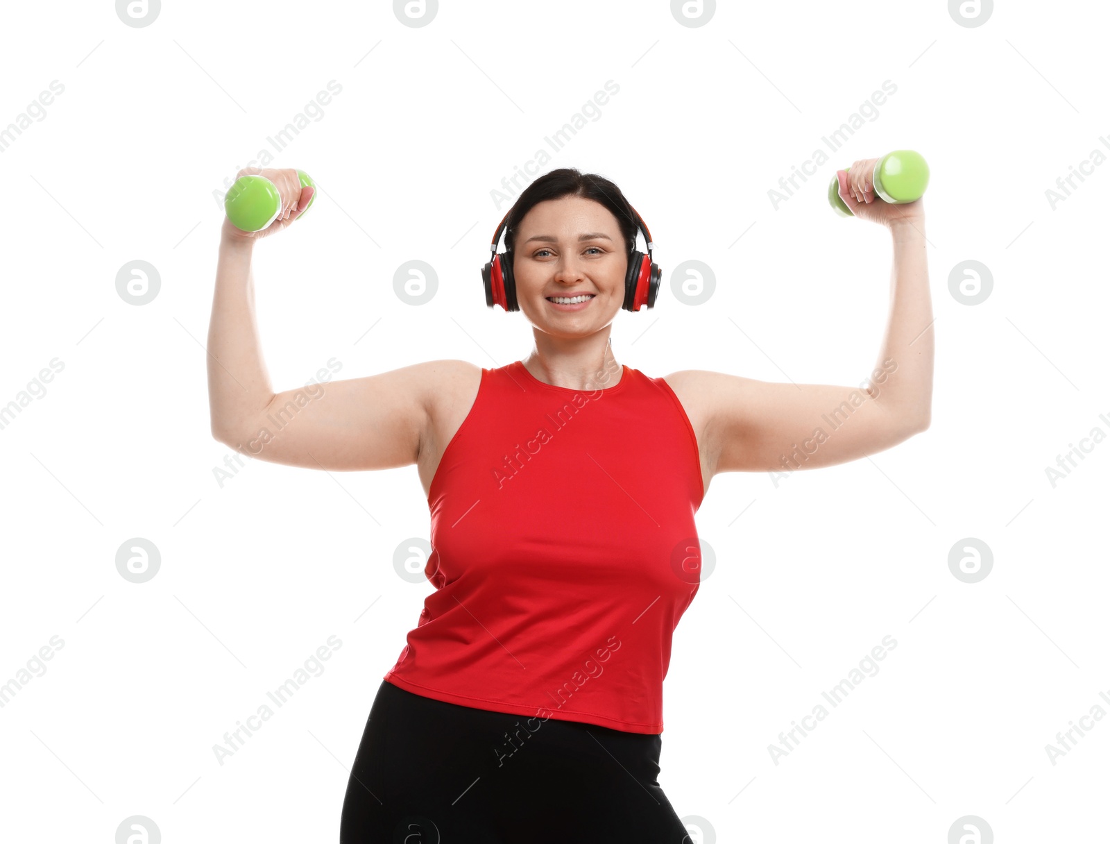 Photo of Plus size woman in gym clothes doing exercise with dumbbells on white background