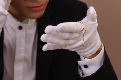 Photo of Appraiser with luxury jewelry on brown background, closeup