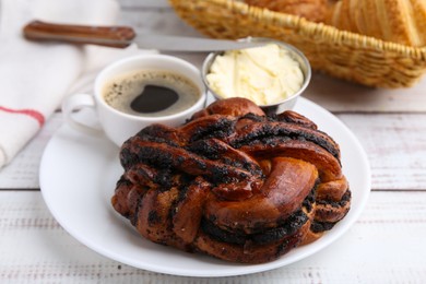 Photo of Delicious poppy seed pastry, butter and coffee on white wooden table, closeup