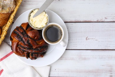 Photo of Delicious poppy seed pastry, butter and coffee on white wooden table, top view. Space for text